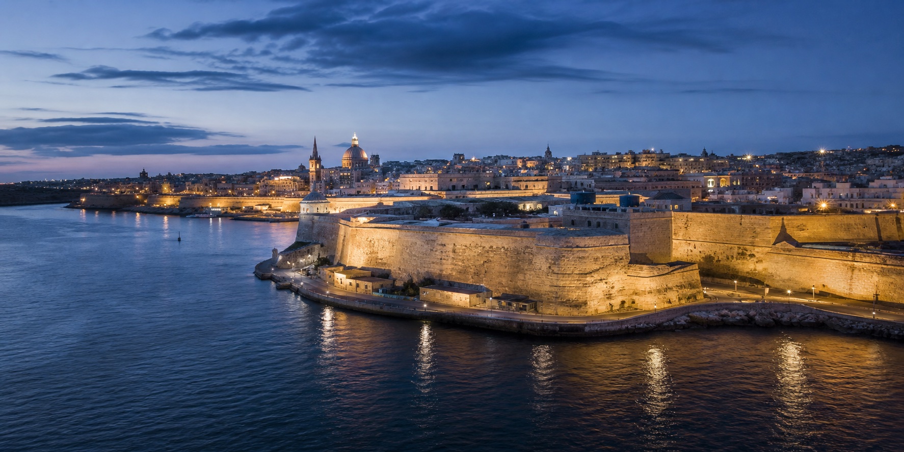 Malta-inspired harbour at blue hour, with limestone architecture and calm Mediterranean water.